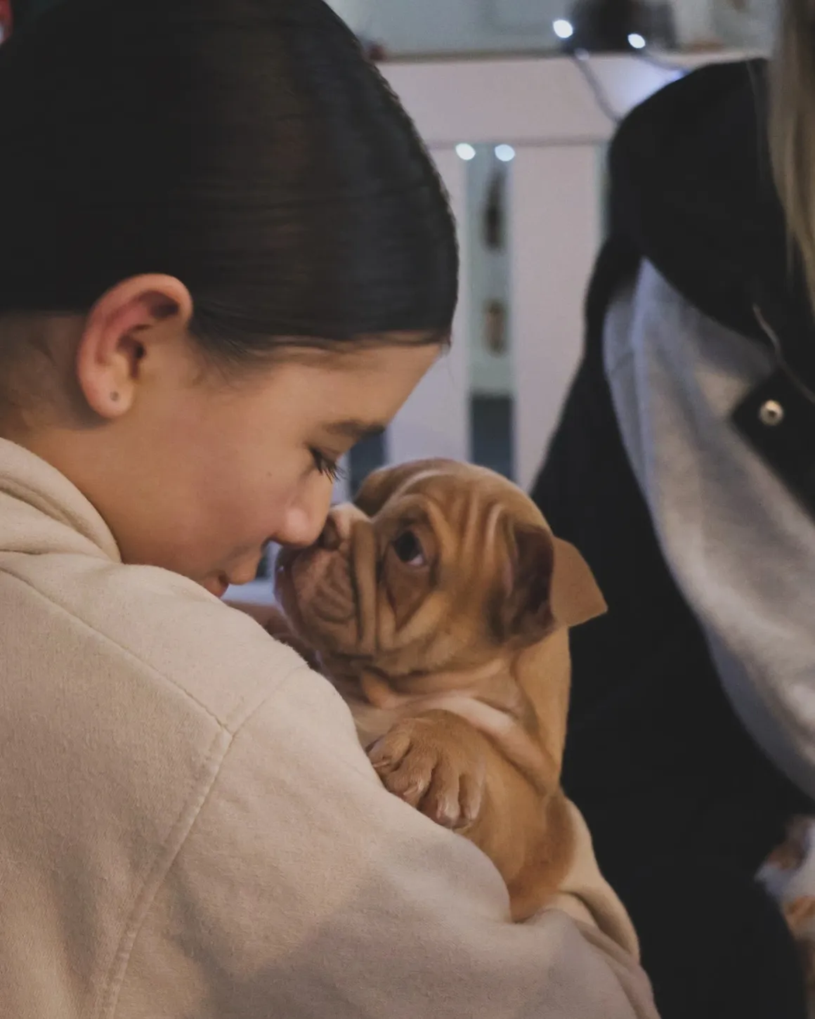 Girl and puppy touching noses