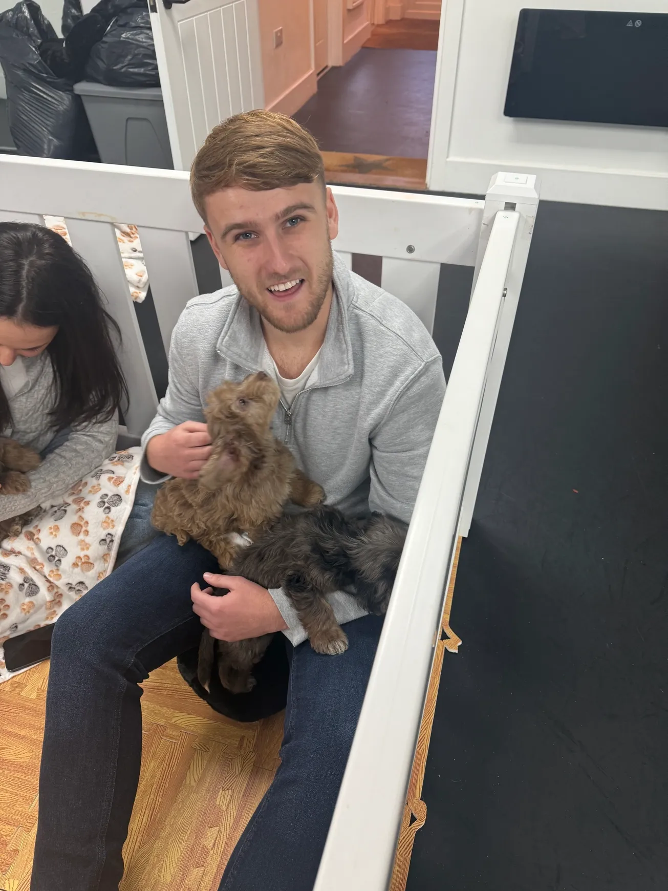 Smiling man cuddling small puppies