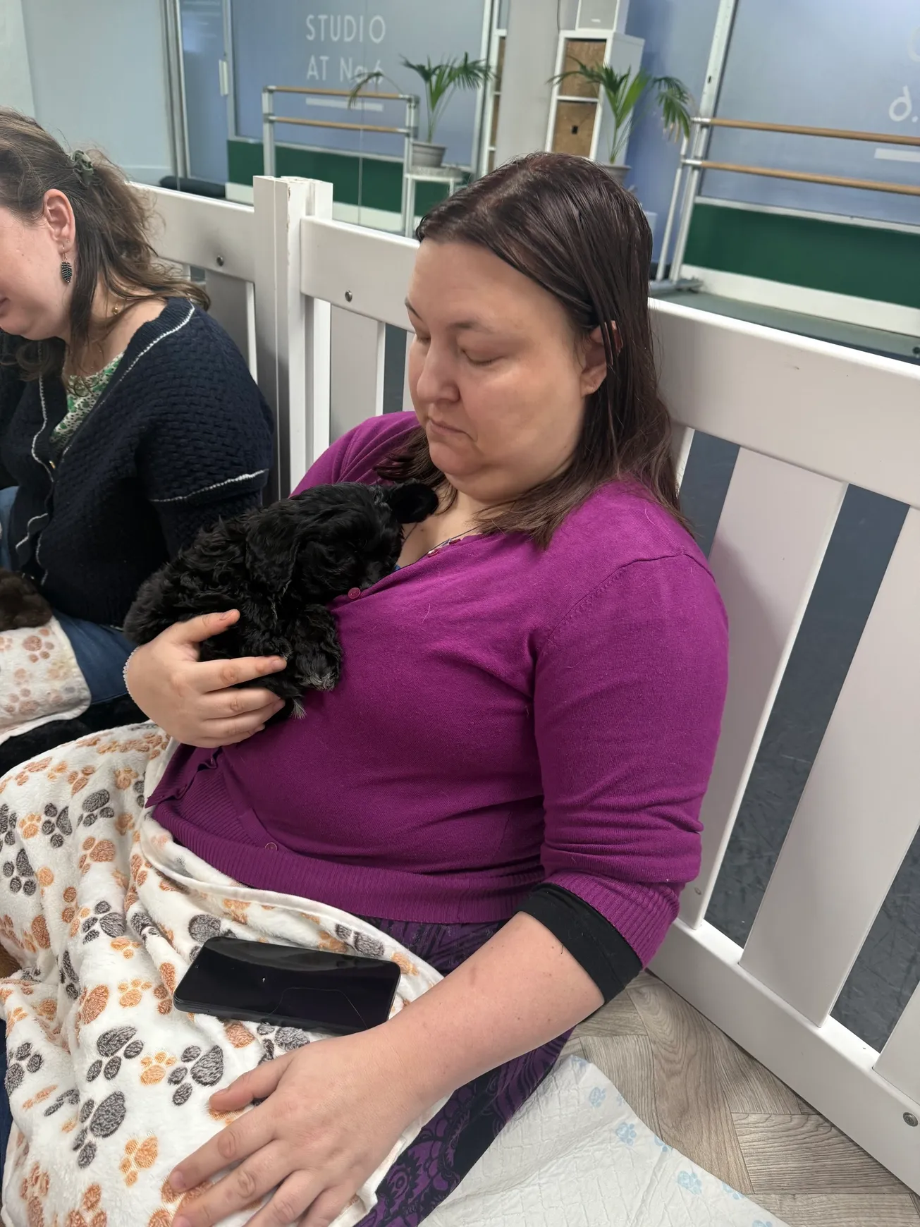 Woman holding black puppy in arms